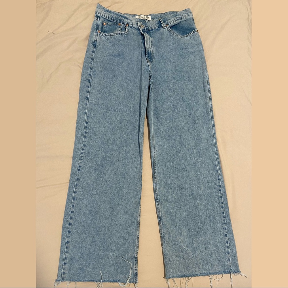 Straight leg light wash jeans with trendy asymmetrical button